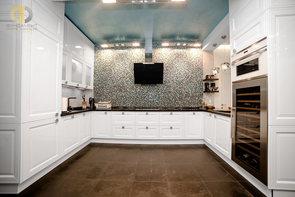 Интерьер белой кухни с отделкой стен мозаикой