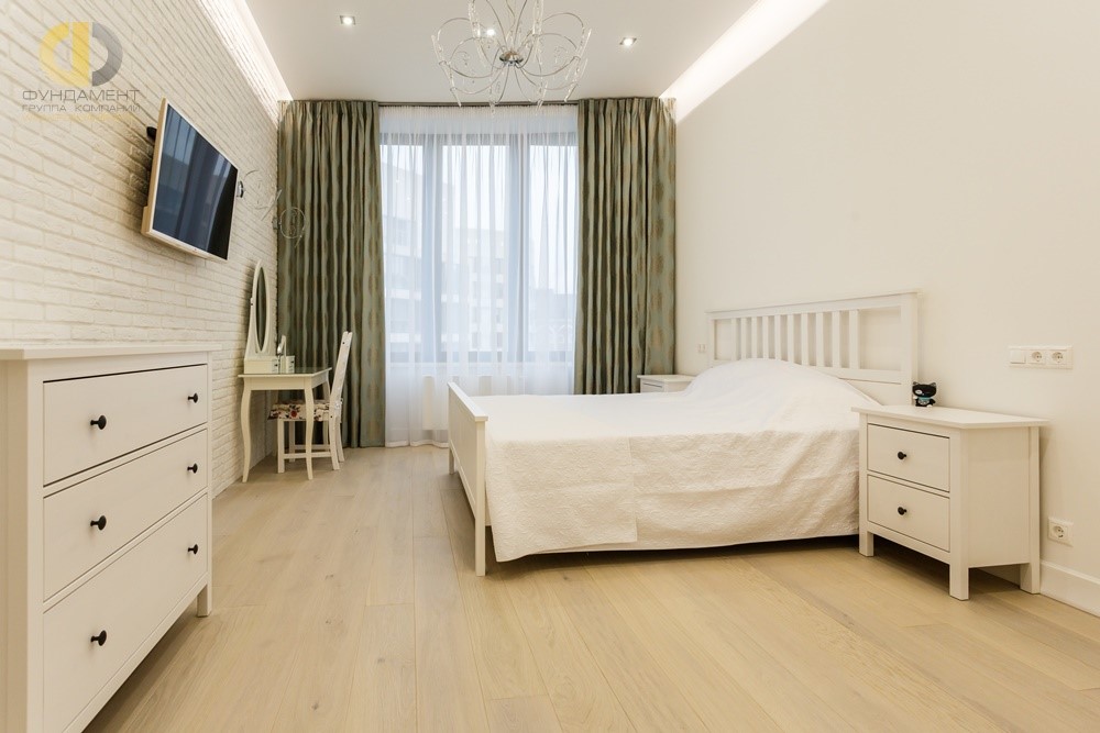 Спальня в светлых тонах с оливковыми шторами и кирпичной кладкой